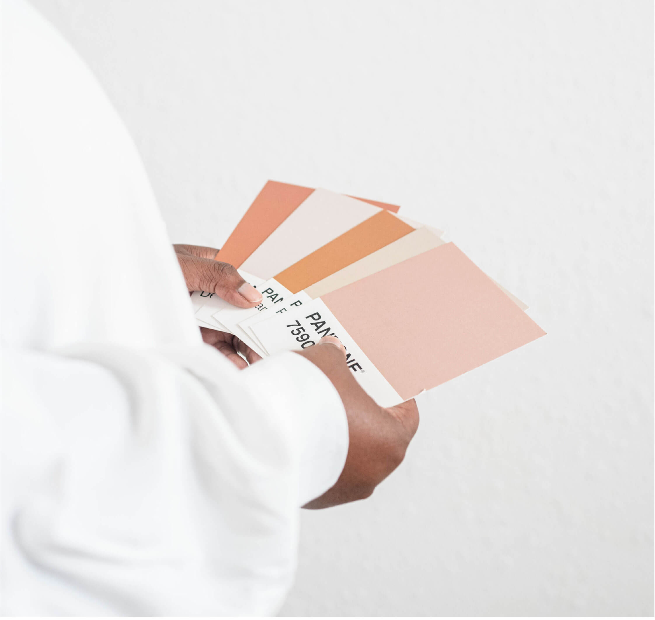 A woman of color holding color swatches.