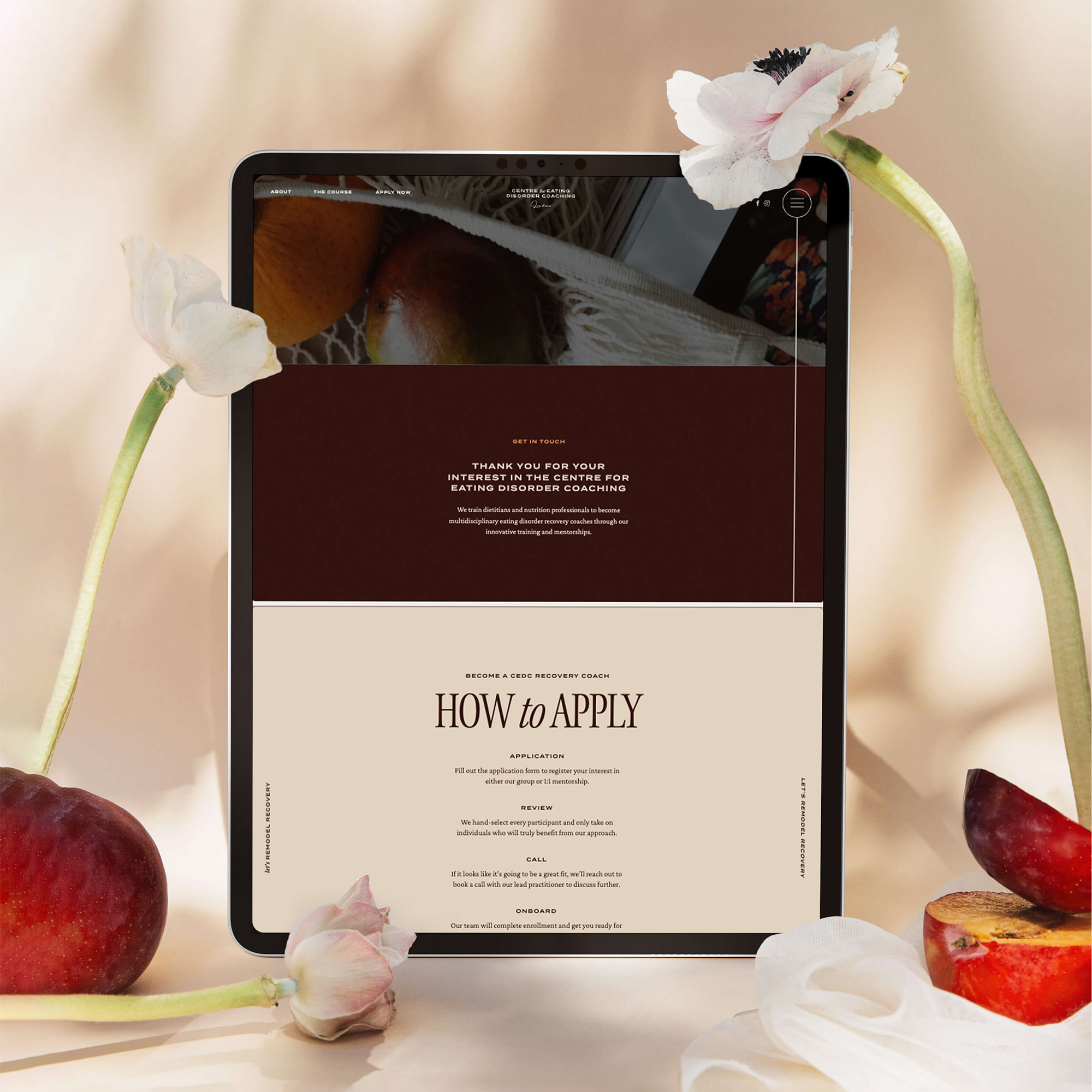 Image of an iPad open to the Centre for Eating Disorder Coaching website, surrounded by flowers and fruits.